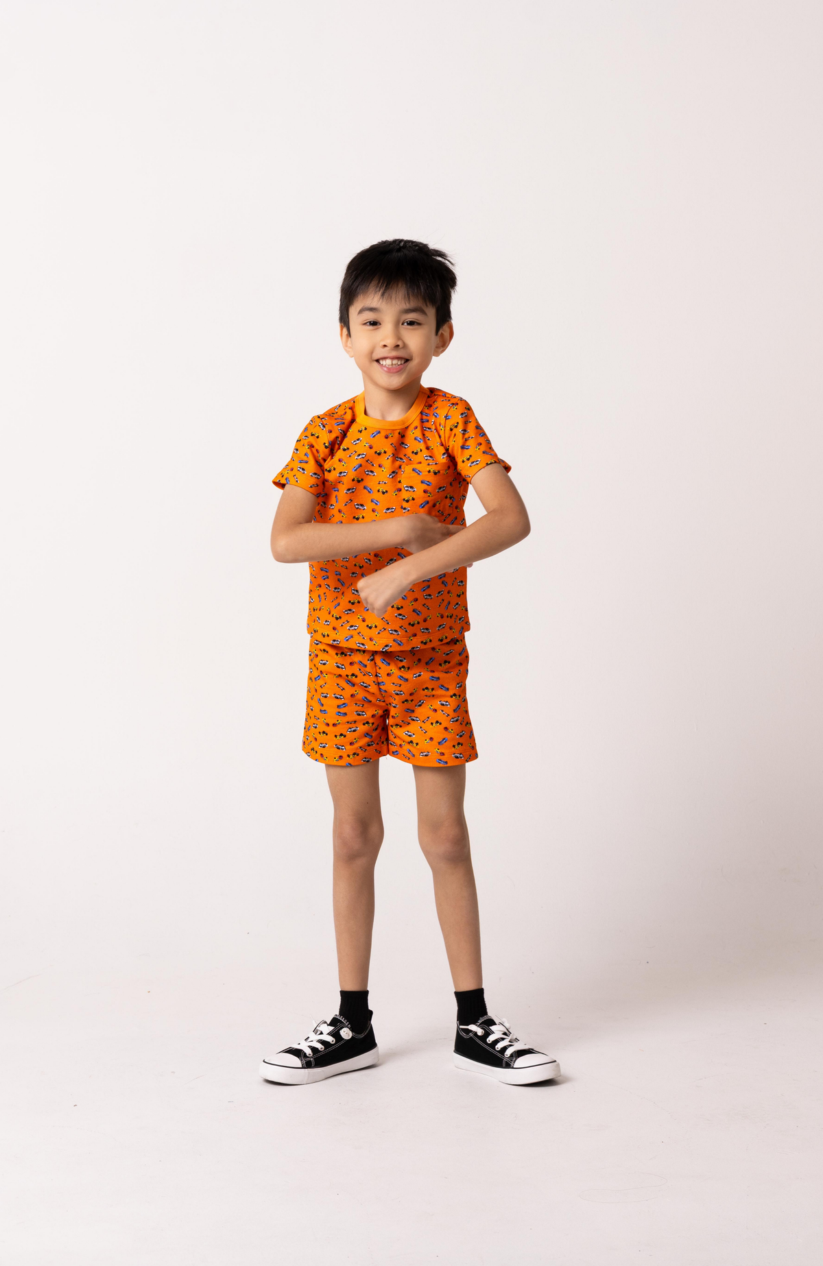 Child wearing an orange outfit with a pattern on a white background