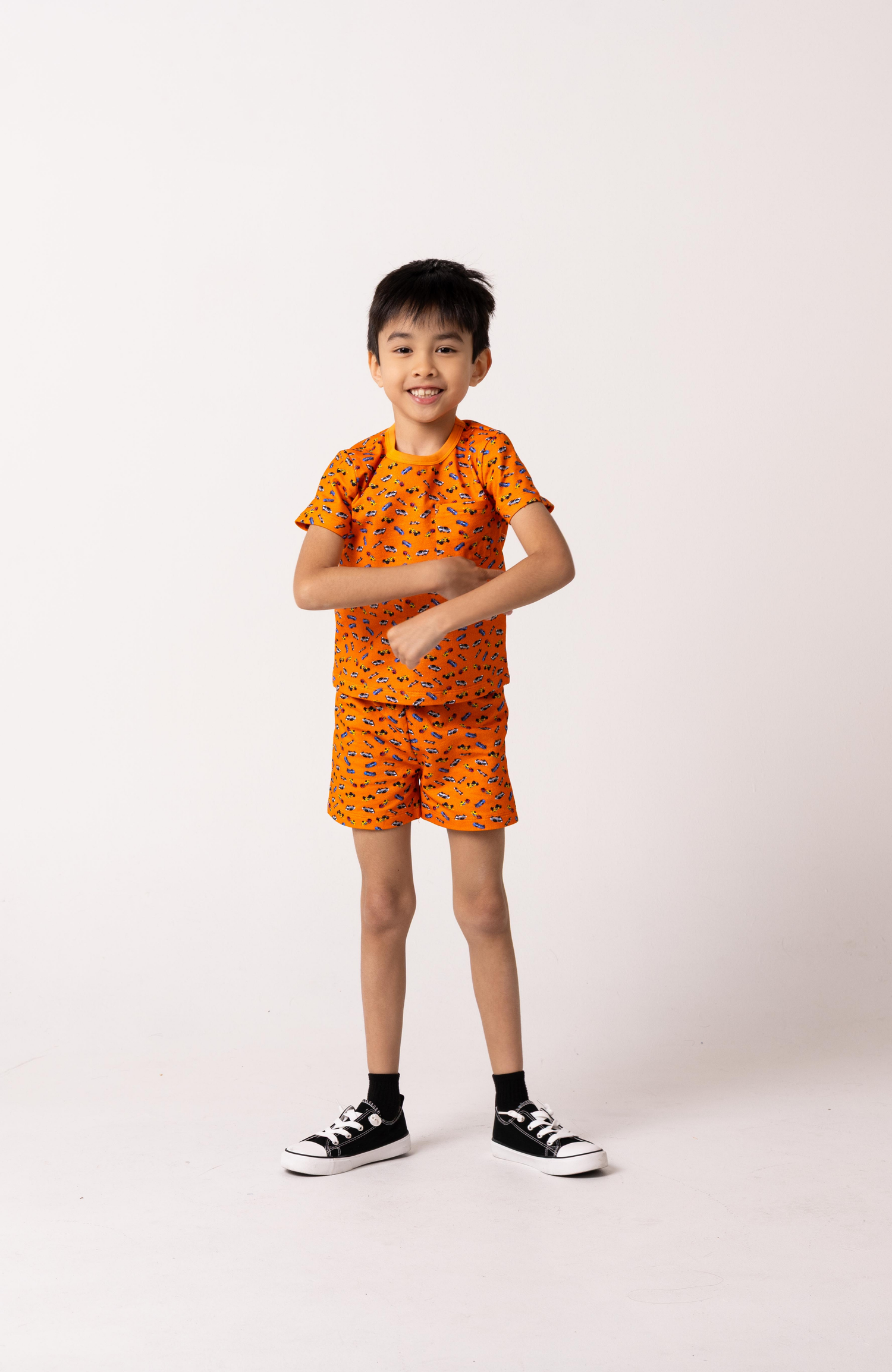 Child wearing an orange outfit with a pattern on a white background