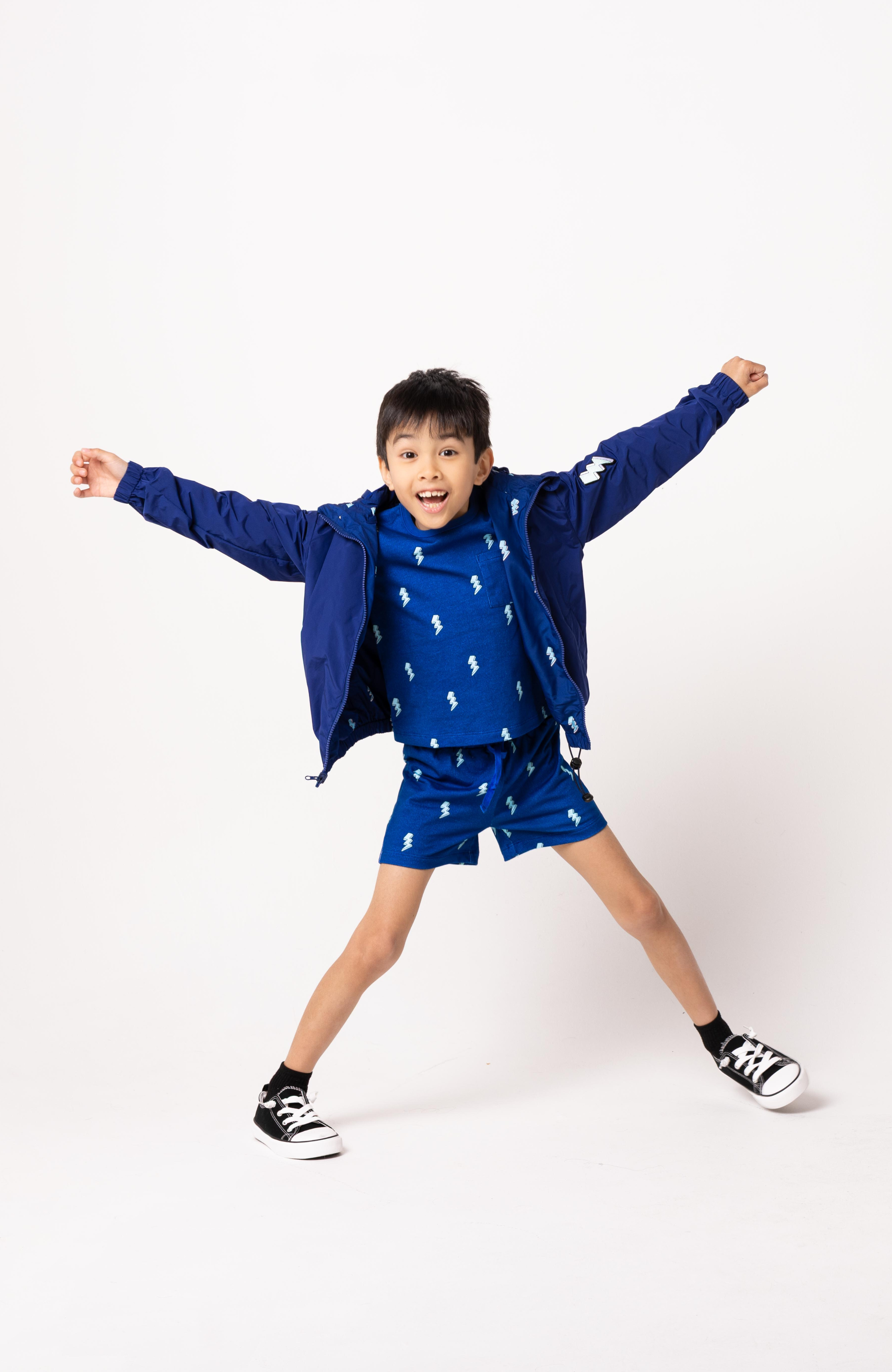 Child wearing a blue outfit with a matching jacket on a white background
